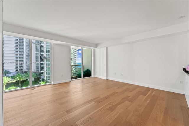 unfurnished room with baseboards and light wood-style flooring