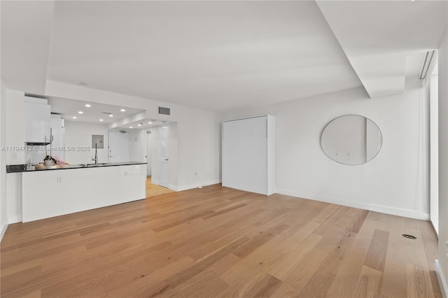 unfurnished living room with recessed lighting, baseboards, visible vents, and light wood finished floors