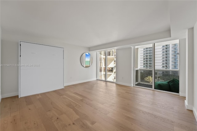 unfurnished room featuring baseboards and light wood-type flooring