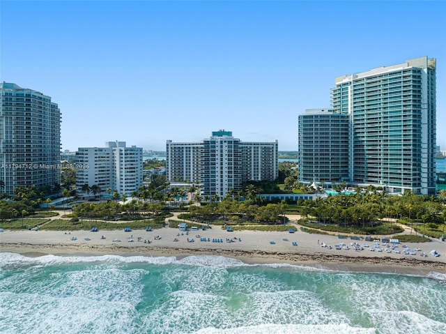 bird's eye view featuring a water view, a view of the beach, and a view of city