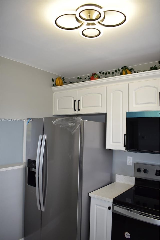 9900 Sunrise Lakes Blvd Unit 309, Sunrise, FL 33322 - kitchen featuring light countertops, white cabinets, and stainless steel appliances