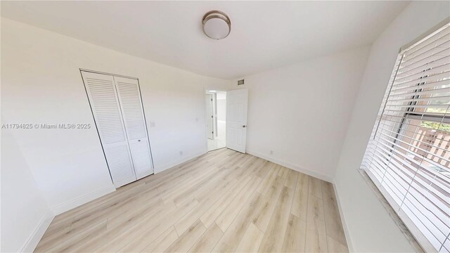 9900 Sunrise Lakes Blvd Unit 309, Sunrise, FL 33322 - unfurnished bedroom featuring light wood-type flooring, baseboards, and a closet