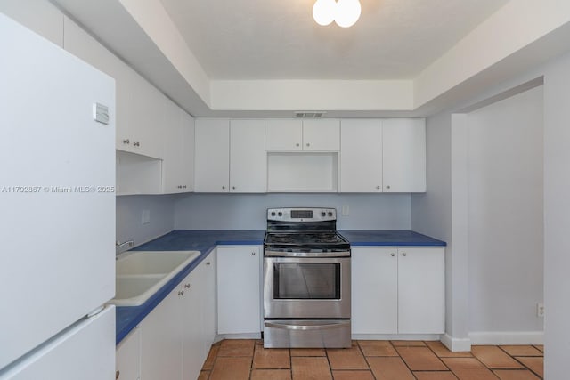 3710 Harrison St Unit 1, Hollywood, FL 33021 - kitchen featuring visible vents, a sink, freestanding refrigerator, stainless steel electric stove, and white cabinetry