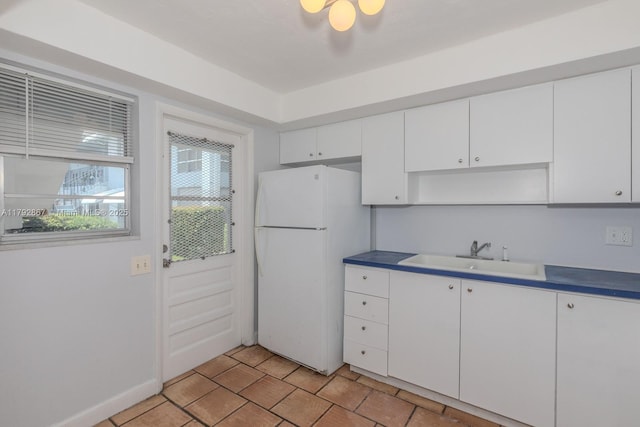 3710 Harrison St Unit 1, Hollywood, FL 33021 - kitchen featuring freestanding refrigerator, white cabinetry, baseboards, and a sink