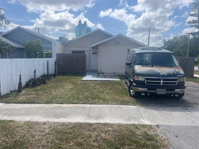 single story home featuring fence, a chimney, and a front lawn