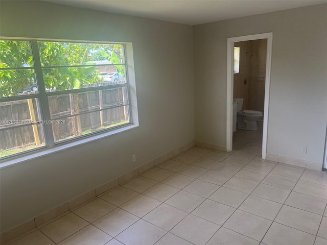 unfurnished room featuring light tile patterned flooring, baseboards, and a healthy amount of sunlight