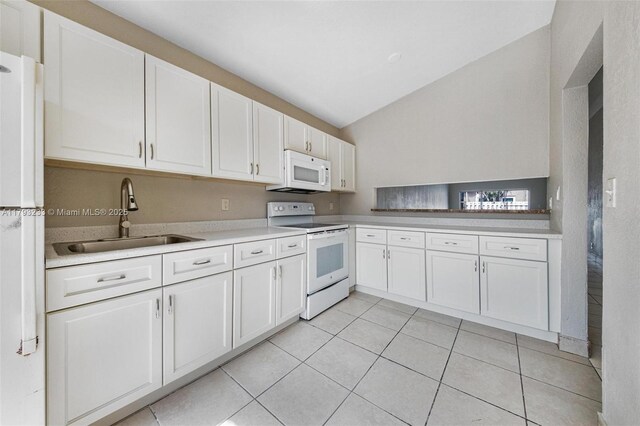 5411 SW 43rd Ter, Dania Beach, FL 33314 - kitchen with lofted ceiling, white appliances, light countertops, white cabinetry, and a sink