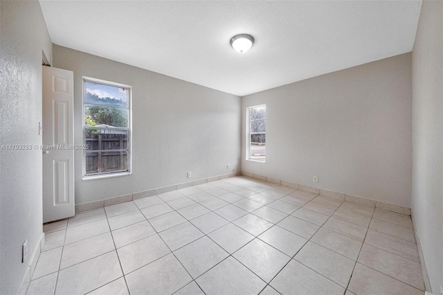5411 SW 43rd Ter, Dania Beach, FL 33314 - unfurnished room featuring light tile patterned floors, baseboards, and a wealth of natural light