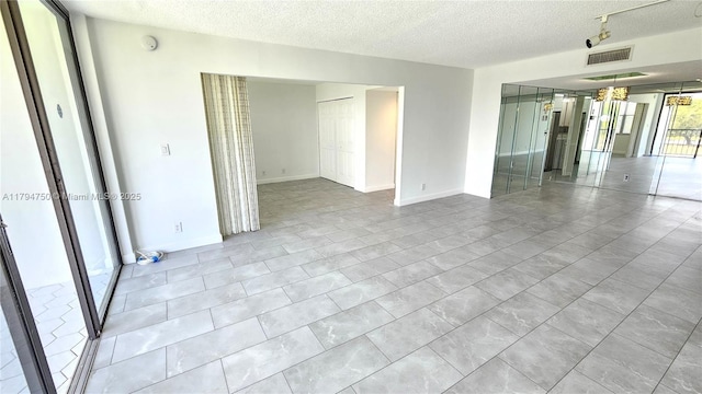 spare room featuring visible vents and a textured ceiling