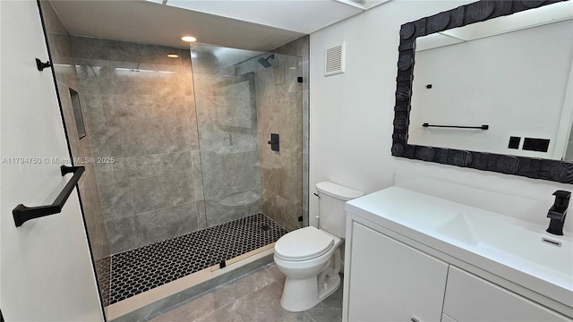 bathroom with visible vents, a shower stall, vanity, tile patterned floors, and toilet