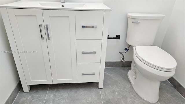 bathroom with a sink, baseboards, and toilet