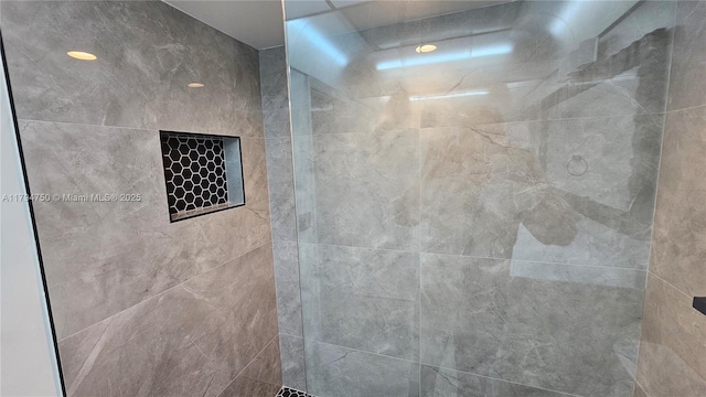 interior details with a tile shower