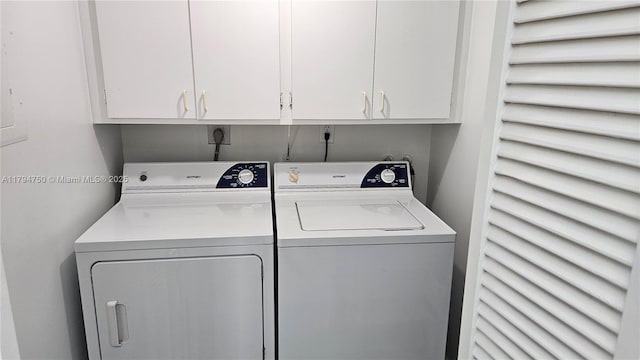 laundry room featuring washing machine and clothes dryer and cabinet space