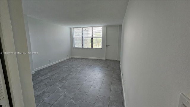unfurnished room with baseboards