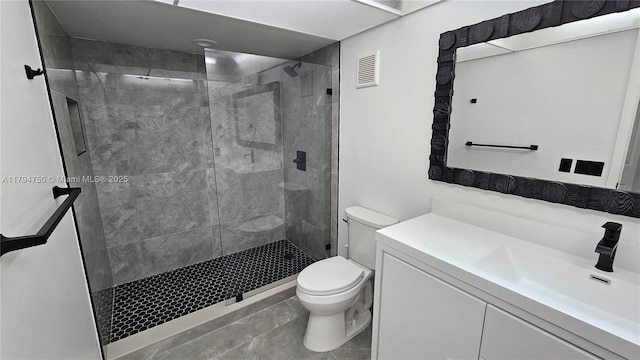bathroom with tile patterned flooring, vanity, toilet, visible vents, and a stall shower