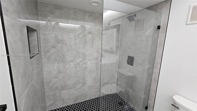 full bath with visible vents, toilet, and a shower stall