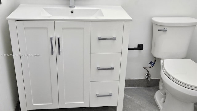 bathroom with vanity, toilet, and concrete floors