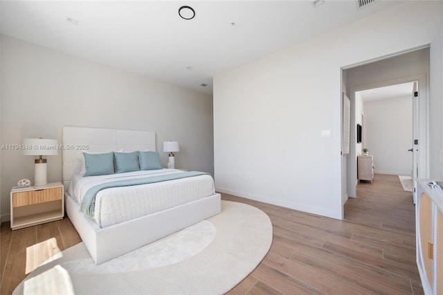 bedroom with baseboards and wood finished floors