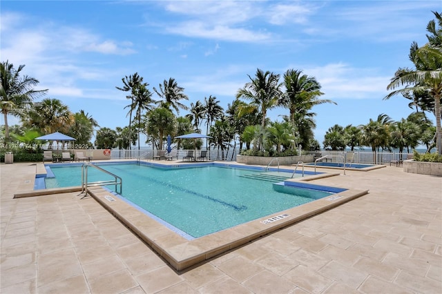 community pool featuring fence and a patio area
