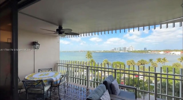 balcony featuring a water view and ceiling fan