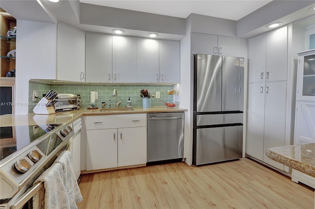 kitchen featuring a sink, light wood-style flooring, white cabinets, and stainless steel appliances