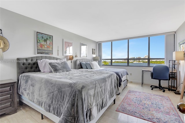 bedroom featuring baseboards and multiple windows