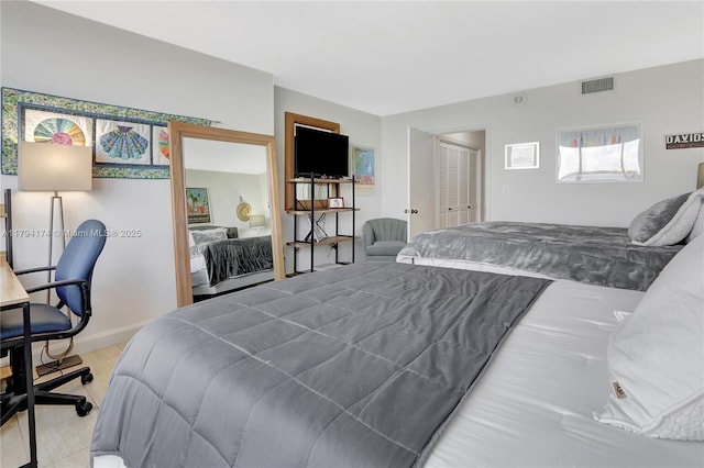 bedroom with baseboards, visible vents, and a closet