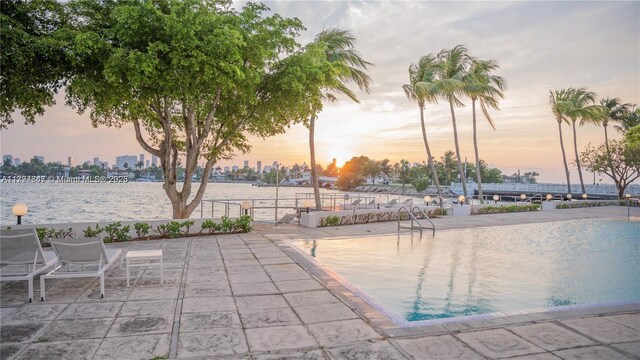 3 Island Ave Unit 07B, Miami Beach, FL 33139 - pool at dusk featuring a patio area and a water view