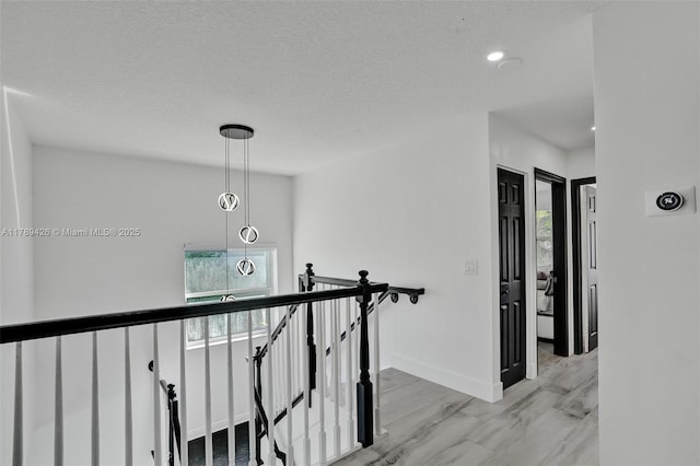 hall featuring recessed lighting, baseboards, and an upstairs landing
