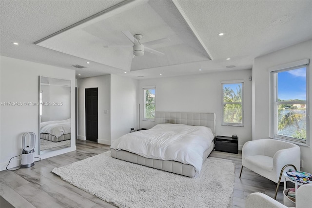 bedroom with recessed lighting, a textured ceiling, visible vents, and wood finished floors