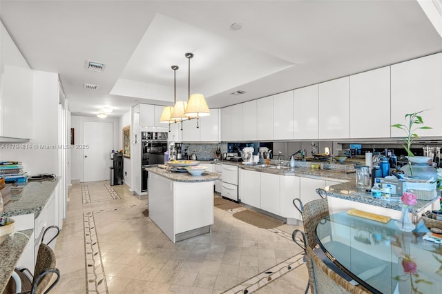 445 Grand Bay Dr Unit 1001, Key Biscayne, FL 33149 - kitchen with a raised ceiling, white dishwasher, inlaid floor details, a center island, and white cabinets