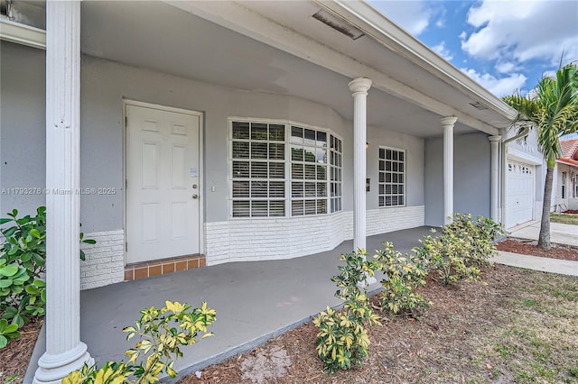4380 NW 4th Ct, Coconut Creek, FL 33066 - view of exterior entry with a porch, brick siding, and a garage