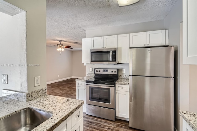 4380 NW 4th Ct, Coconut Creek, FL 33066 - kitchen with white cabinets, ceiling fan, a textured ceiling, stainless steel appliances, and dark wood-style floors