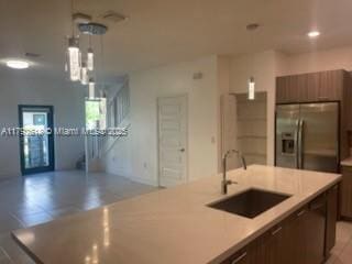 4755 NW 83rd Path, Doral, FL 33166 - kitchen featuring open floor plan, an island with sink, stainless steel refrigerator with ice dispenser, light countertops, and a sink