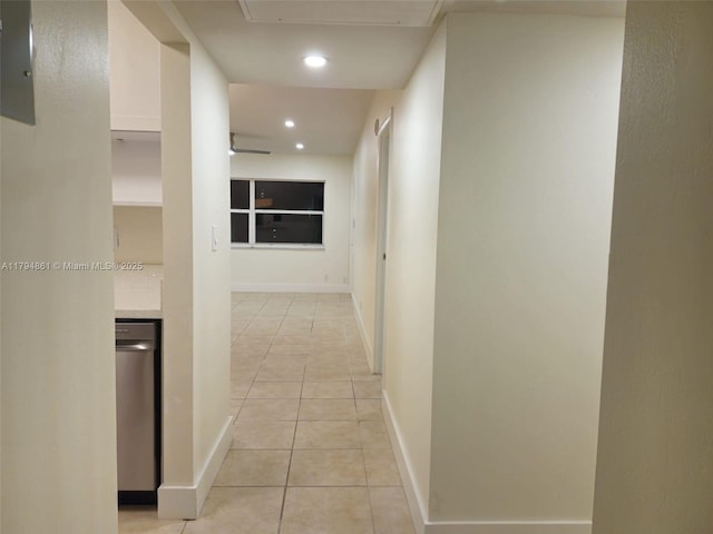 hallway featuring baseboards, attic access, recessed lighting, and light tile patterned flooring