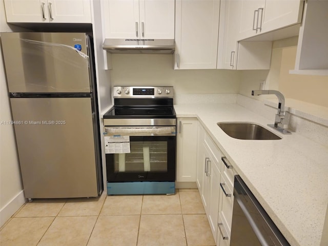 kitchen with a sink, white cabinets, under cabinet range hood, stainless steel appliances, and light tile patterned flooring