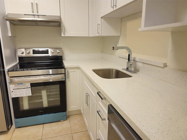 kitchen featuring appliances with stainless steel finishes, light stone countertops, a sink, under cabinet range hood, and white cabinetry