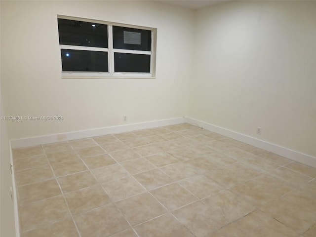 unfurnished room with baseboards