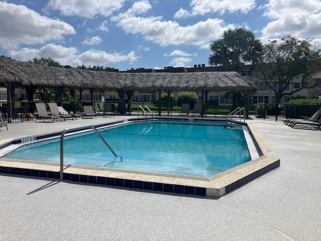 community pool featuring fence and a patio area