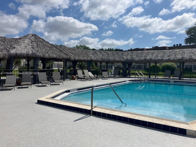 pool with a patio and fence