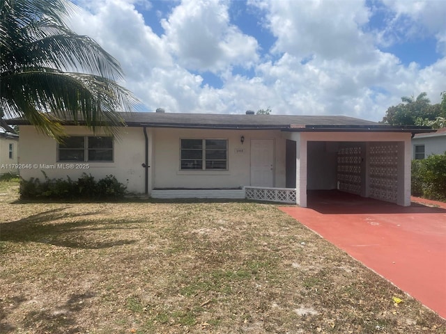 ranch-style house with stucco siding, an attached carport, driveway, and a front yard
