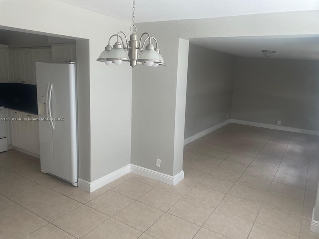 unfurnished dining area with light tile patterned flooring, baseboards, and a chandelier