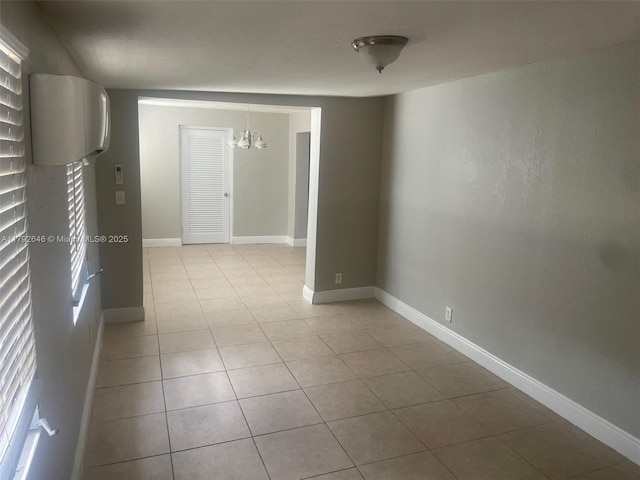 tiled empty room with baseboards and an inviting chandelier