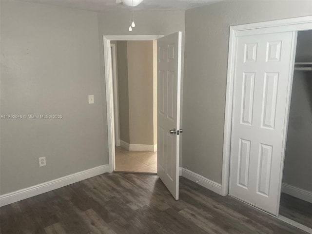 unfurnished bedroom featuring dark wood-type flooring and baseboards