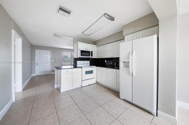 6808 SW 22nd Ct, Miramar, FL 33023 - kitchen featuring white appliances, dark countertops, white cabinetry, a sink, and light tile patterned floors