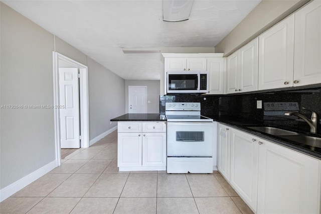 6808 SW 22nd Ct, Miramar, FL 33023 - kitchen featuring white range with electric cooktop, white cabinetry, dark countertops, and light tile patterned floors