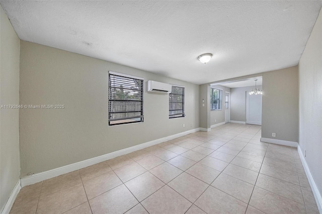 6808 SW 22nd Ct, Miramar, FL 33023 - unfurnished room with a wall mounted air conditioner, a chandelier, a textured ceiling, light tile patterned flooring, and baseboards