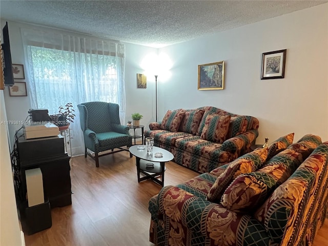 living area with a textured ceiling and wood finished floors