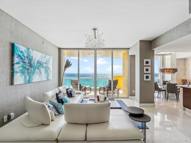 living area featuring a water view, a notable chandelier, and a wall of windows