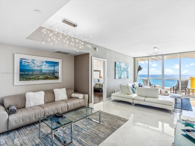 living room featuring a water view, visible vents, an inviting chandelier, and marble finish floor